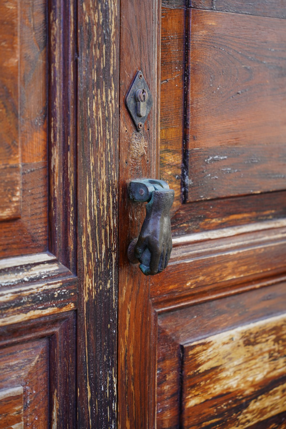 a close up of a door handle on a wooden door