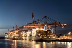 a large cargo ship docked in a harbor at night