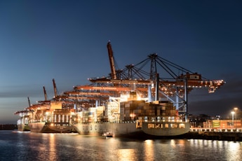 a large cargo ship docked in a harbor at night