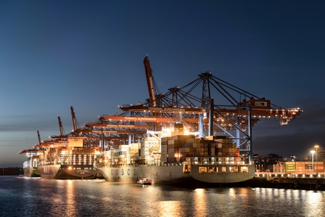 a large cargo ship docked in a harbor at night
