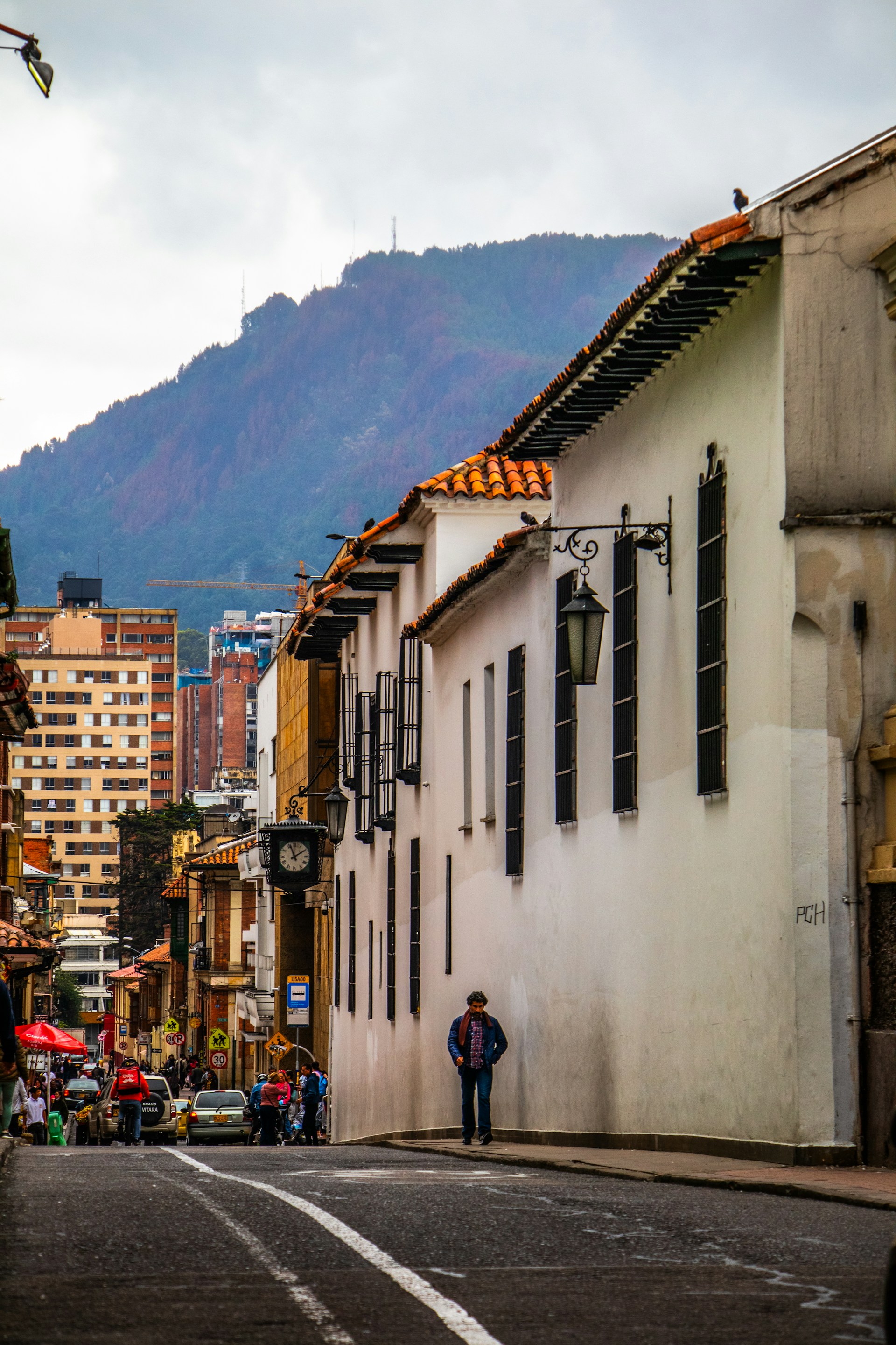 a man walking down a street next to tall buildings