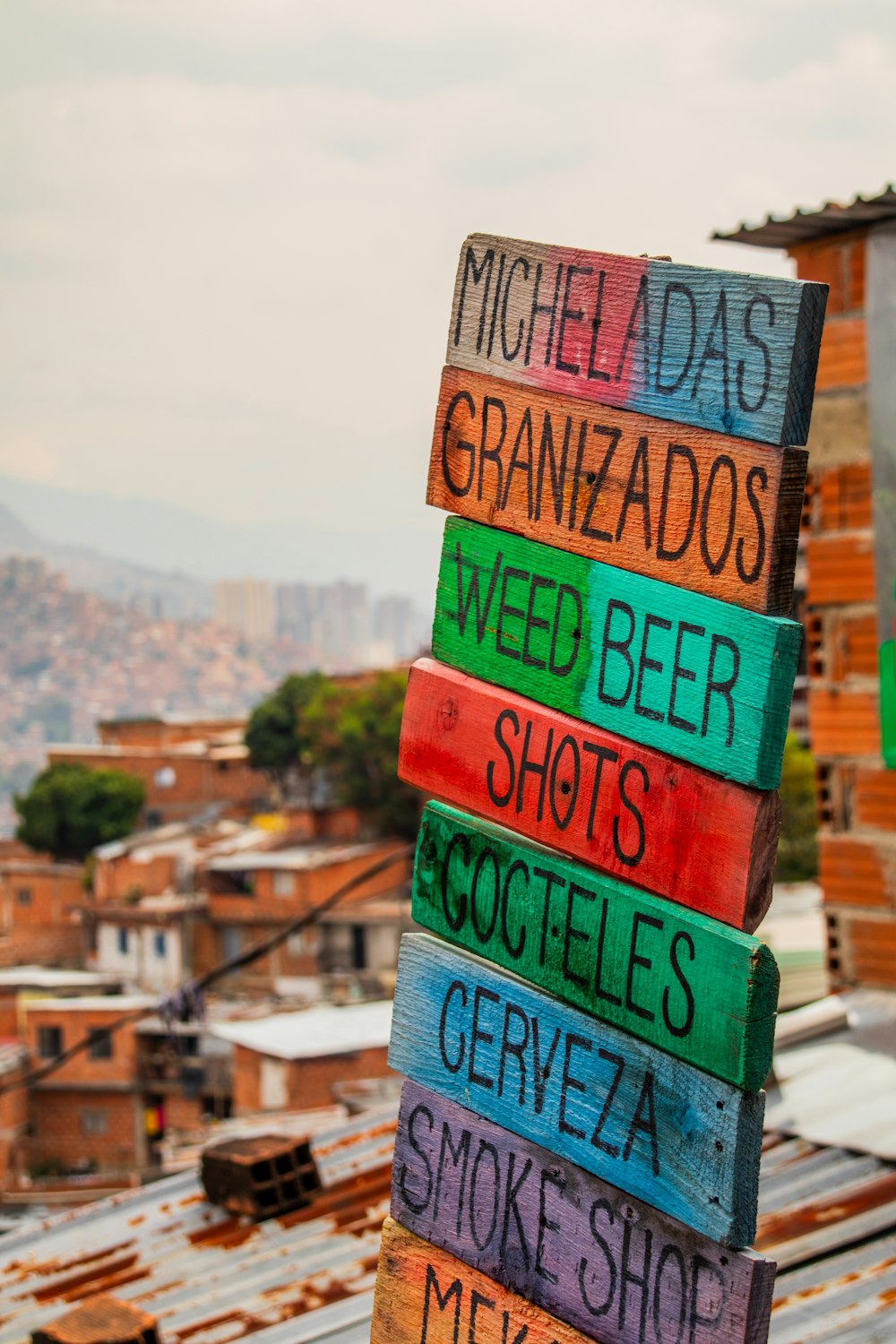 a stack of colorful wooden signs sitting on top of a roof