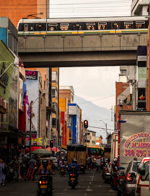 a city street with a train going over a bridge