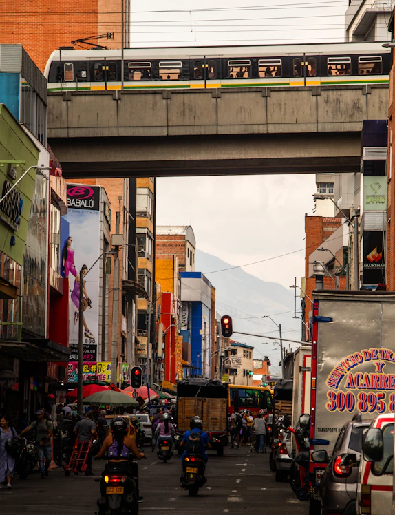 a city street with a train going over a bridge