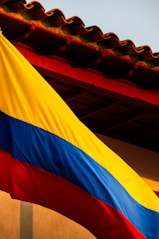a large rainbow colored flag hanging from the side of a building