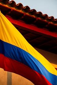 a large rainbow colored flag hanging from the side of a building