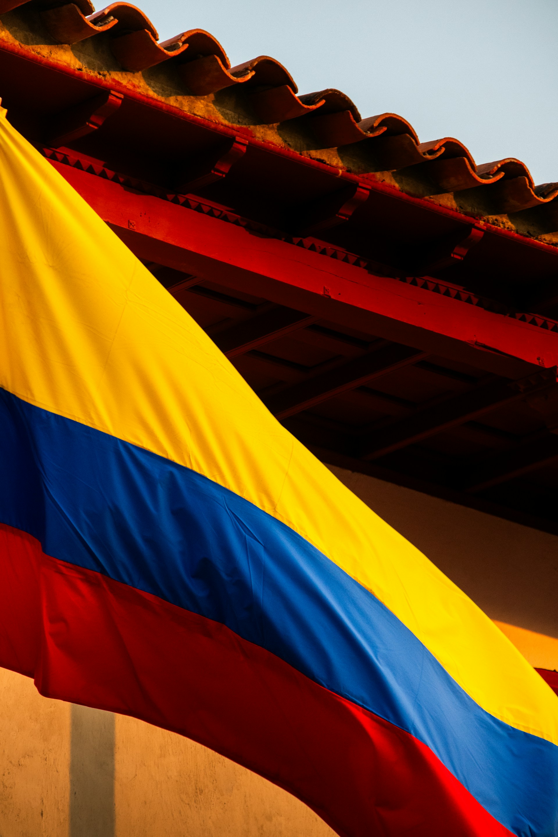 a large rainbow colored flag hanging from the side of a building