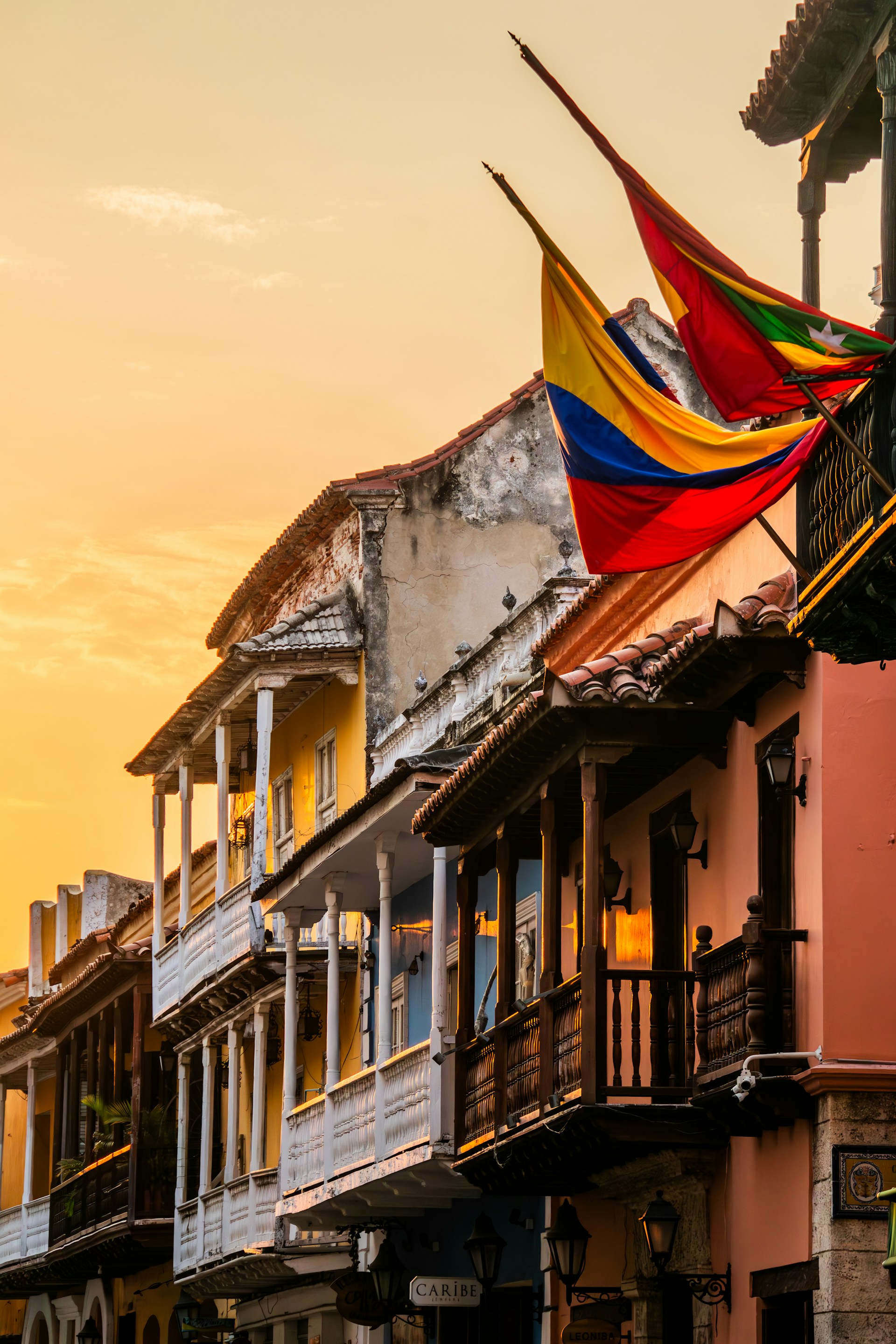 a row of buildings with a rainbow flag on top