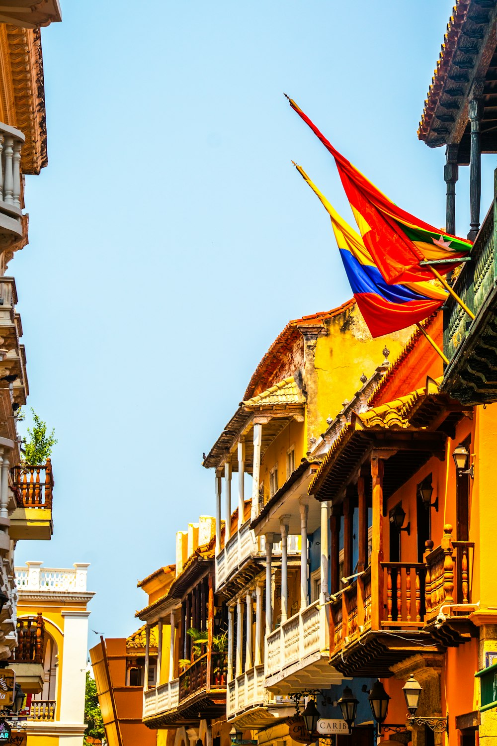 a row of buildings with colorful flags hanging from the balconies