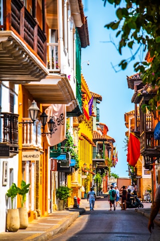 people walking down a street lined with tall buildings