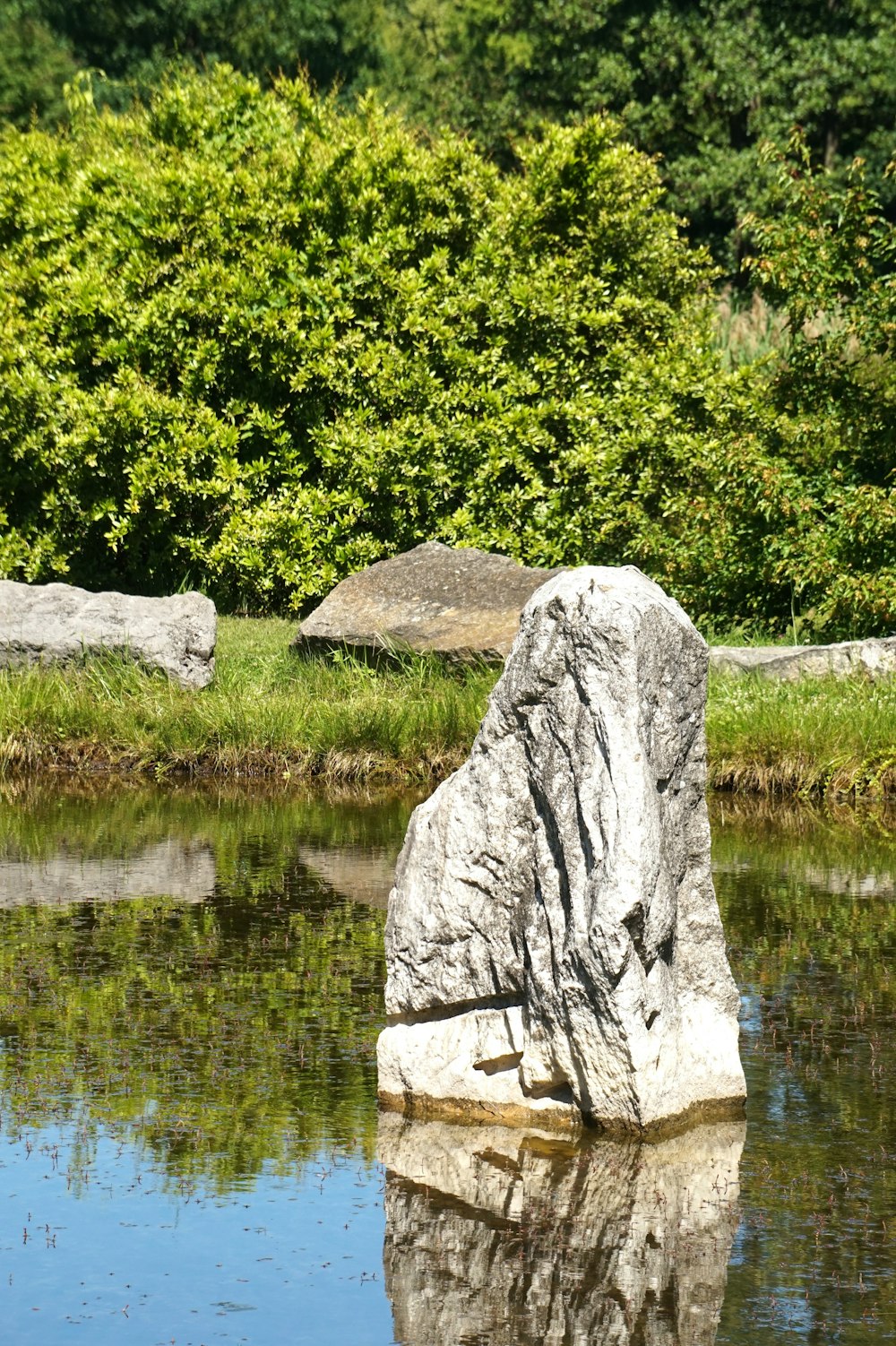 a large rock sitting in the middle of a body of water