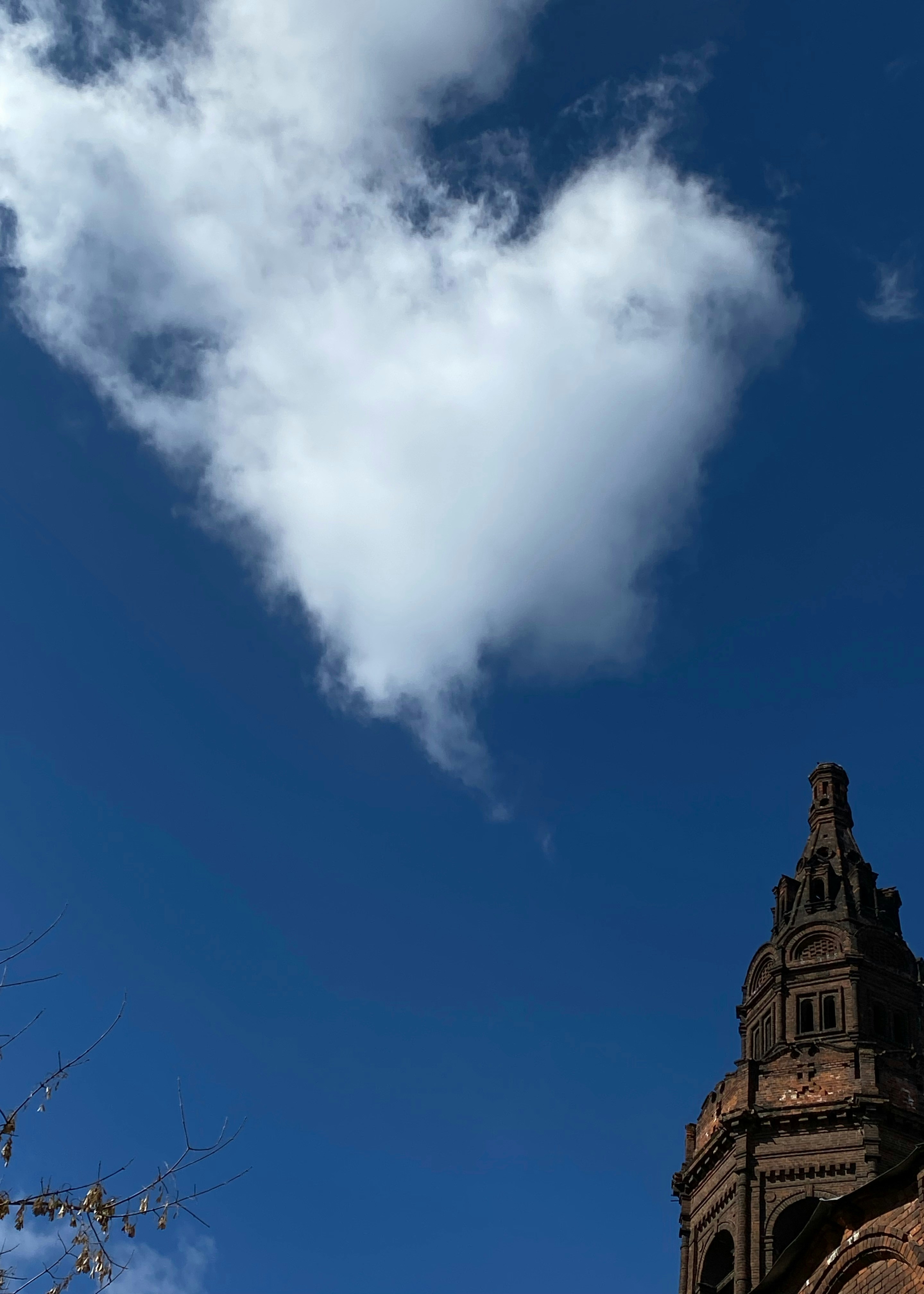 a very tall tower with a very big cloud in the sky