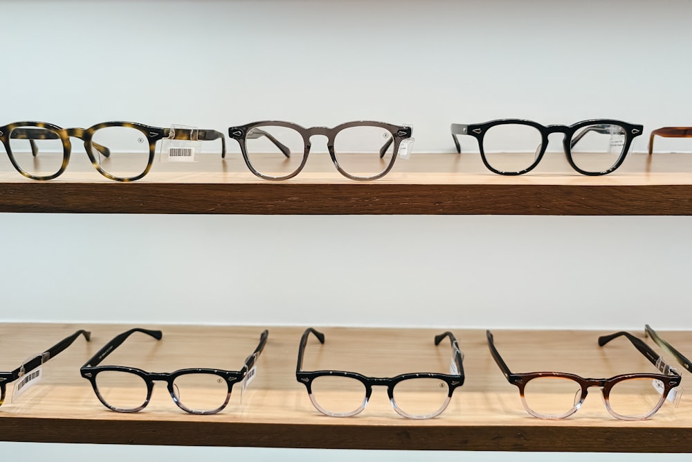 a row of glasses sitting on top of a wooden shelf