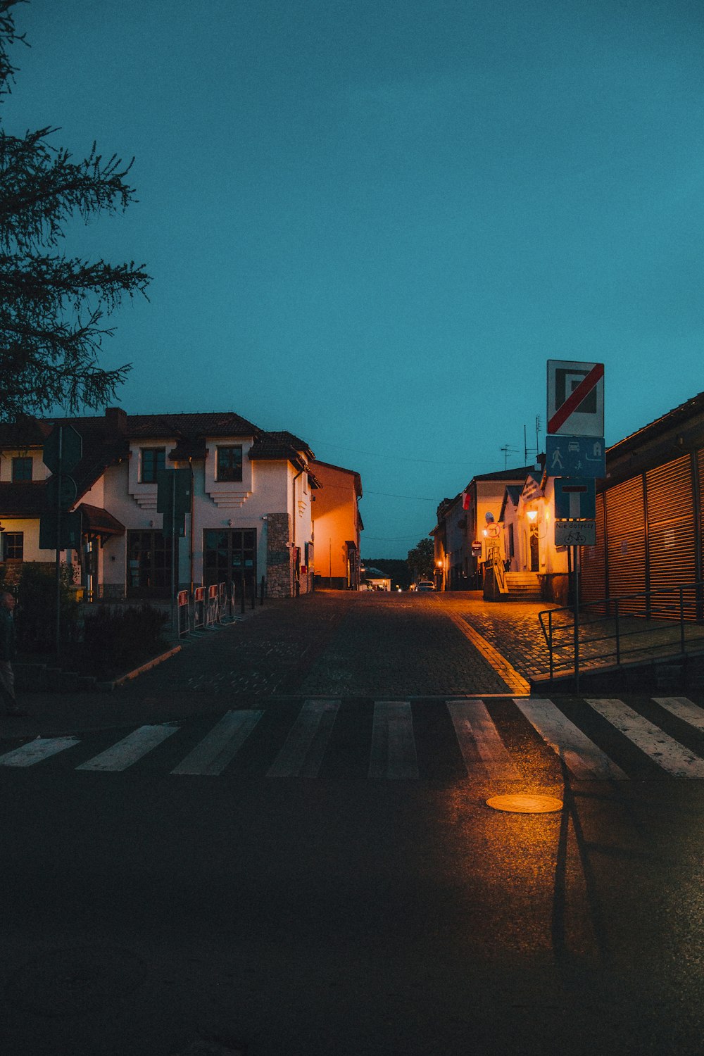 an empty street at night with a few buildings