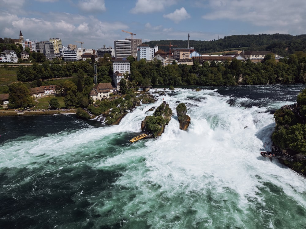 une vue d’une rivière avec des rapides et une ville en arrière-plan