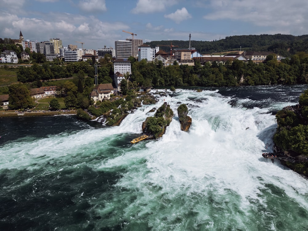 a view of a river with rapids and a city in the background