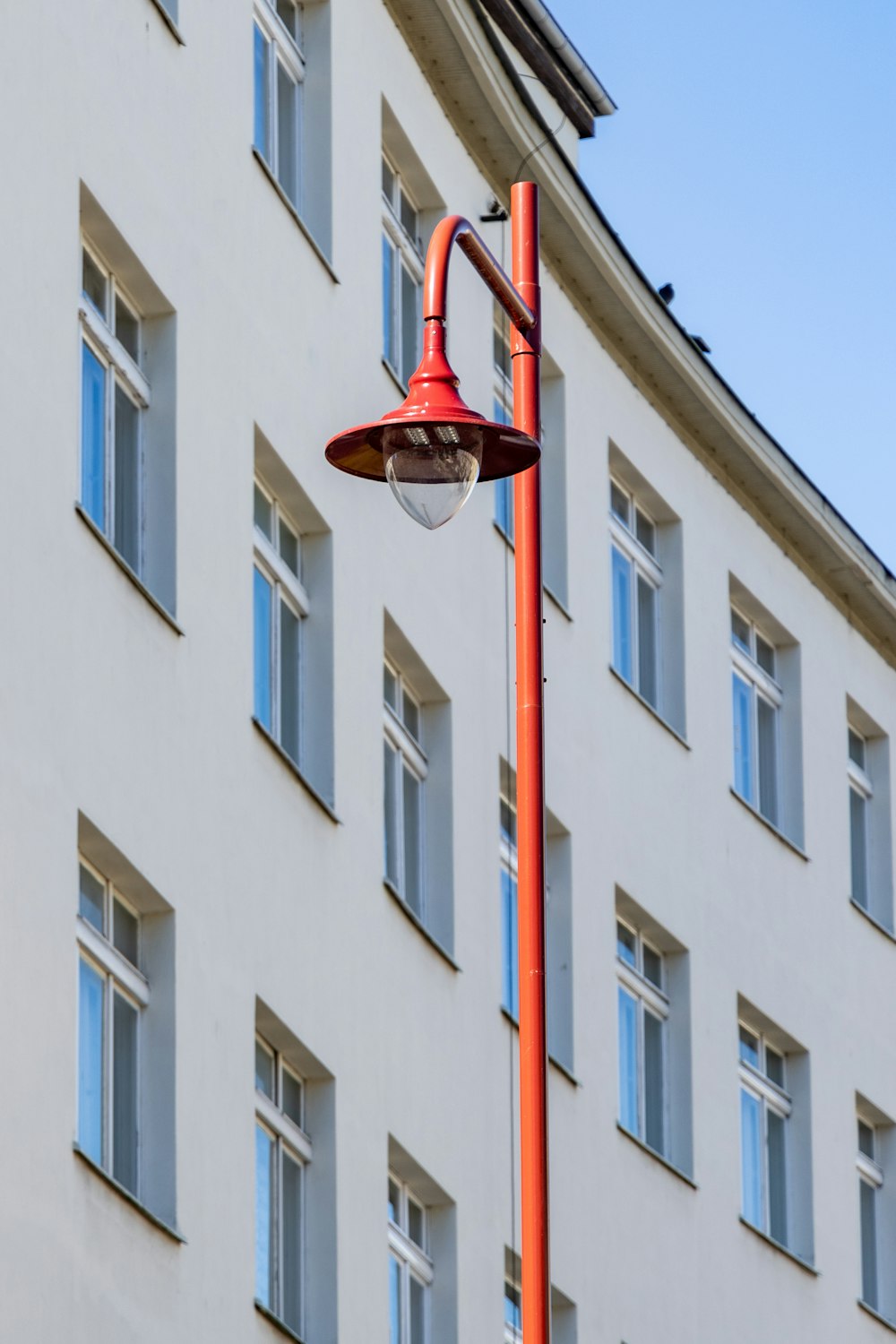 a red street light sitting next to a tall building