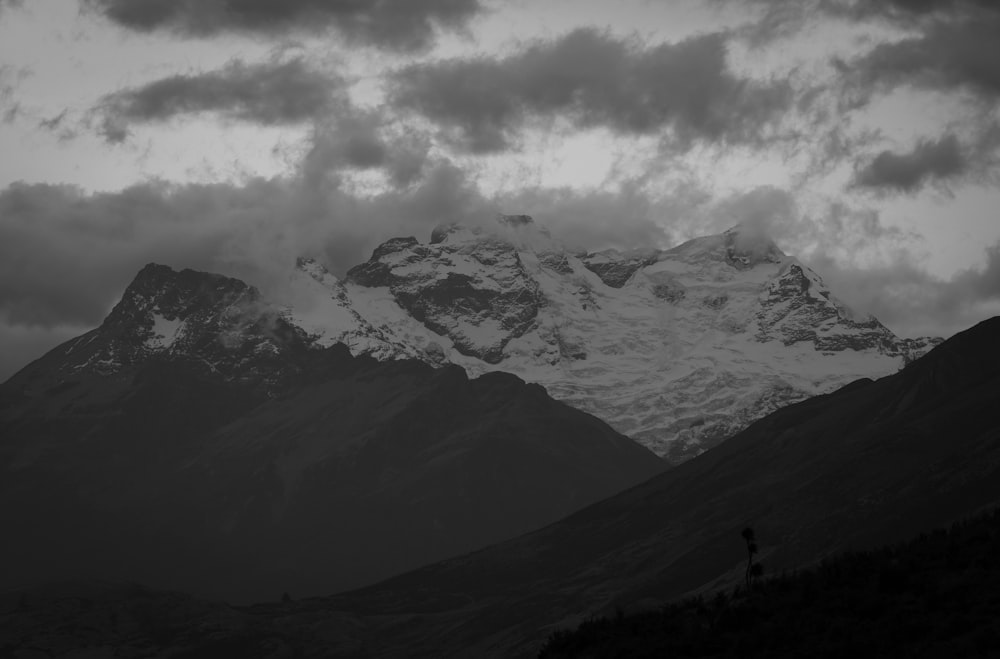 a man standing on top of a mountain under a cloudy sky