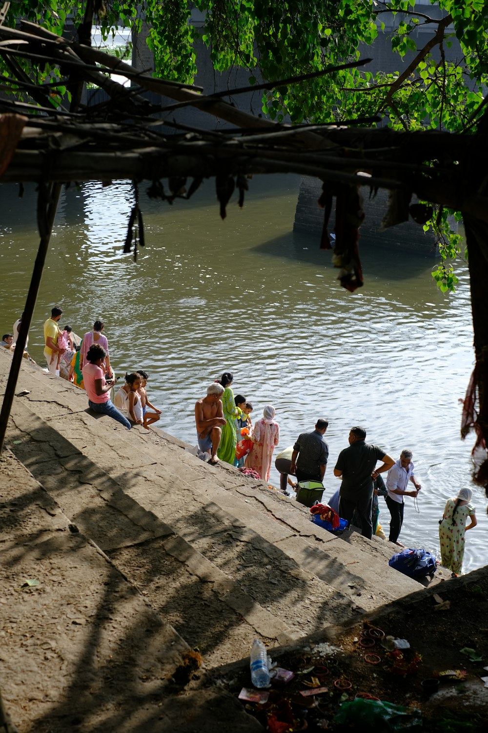 a group of people sitting on the bank of a river
