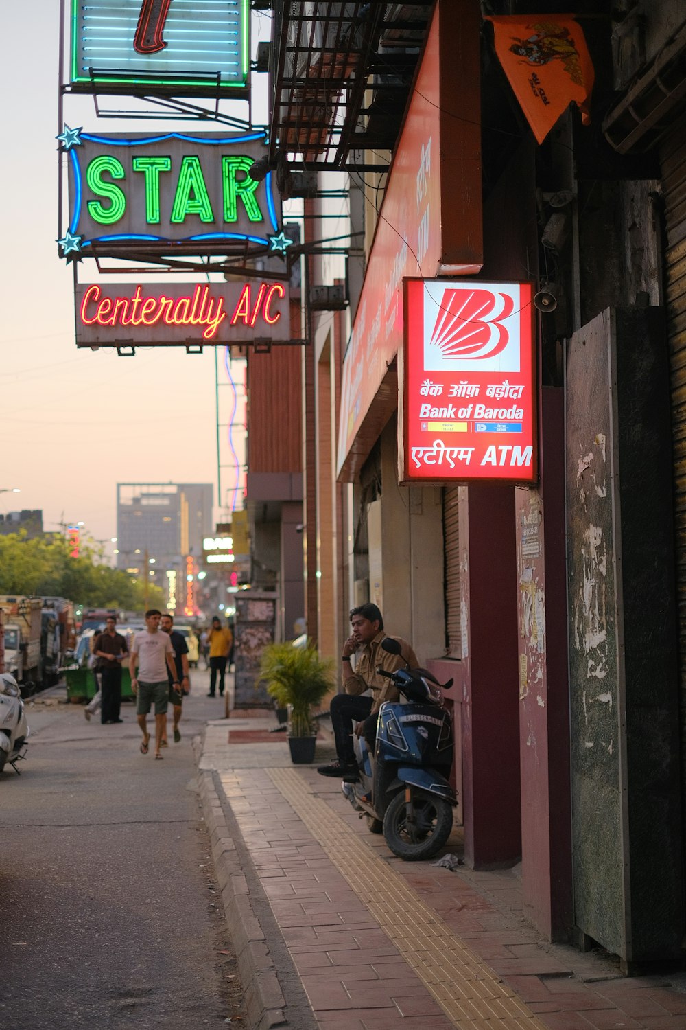 a man riding a motorcycle down a street next to a tall building