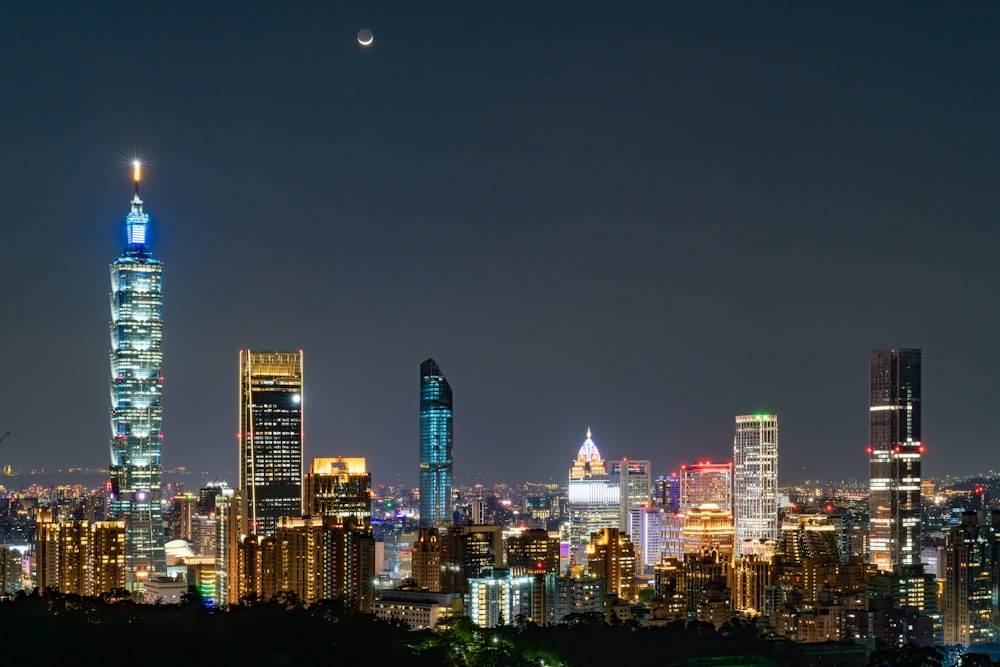 Una vista de una ciudad por la noche desde la cima de una colina