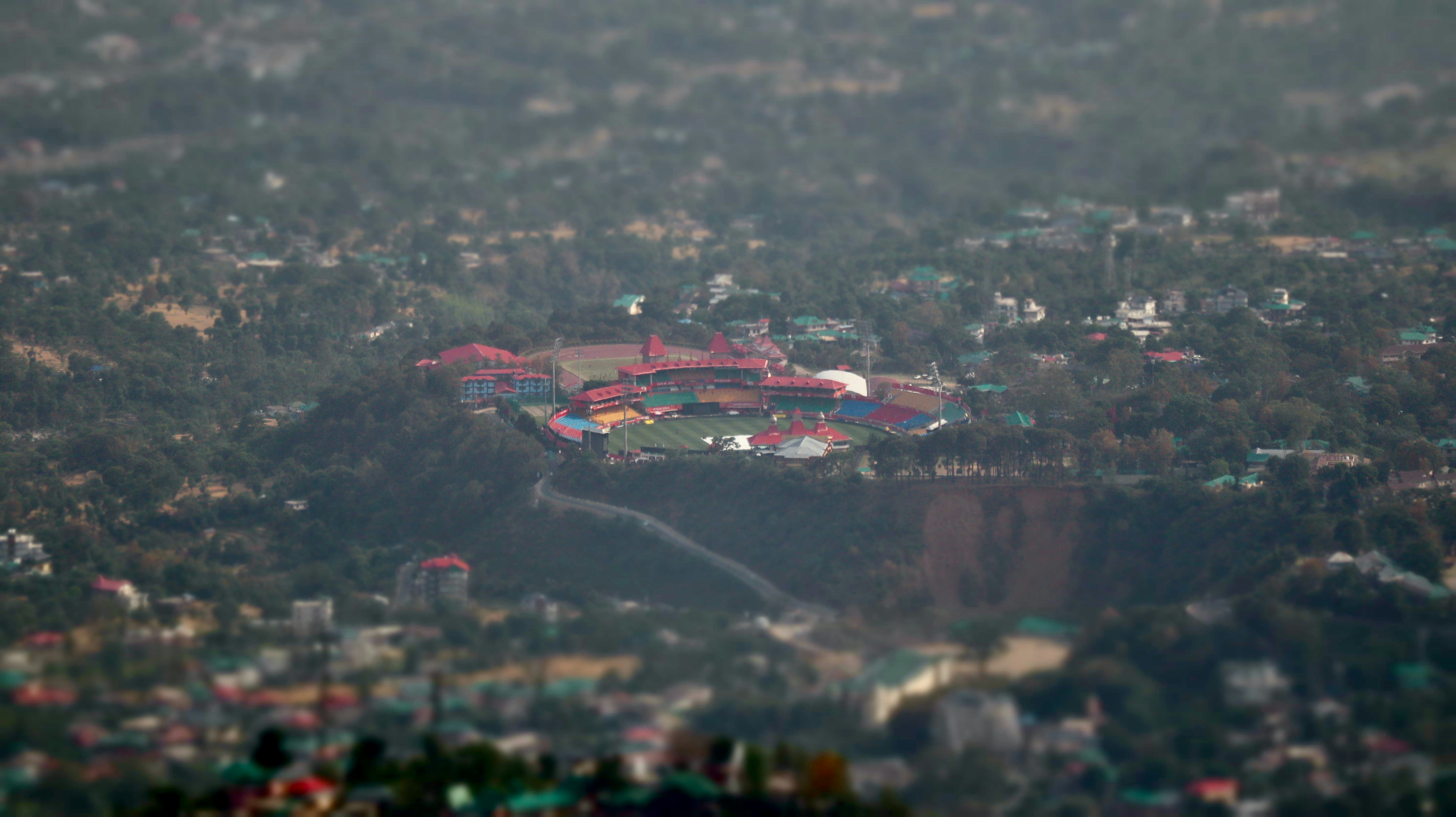 an aerial view of a city with lots of trees, Birds eye view of Dharamshala cricket stadium, India. World
