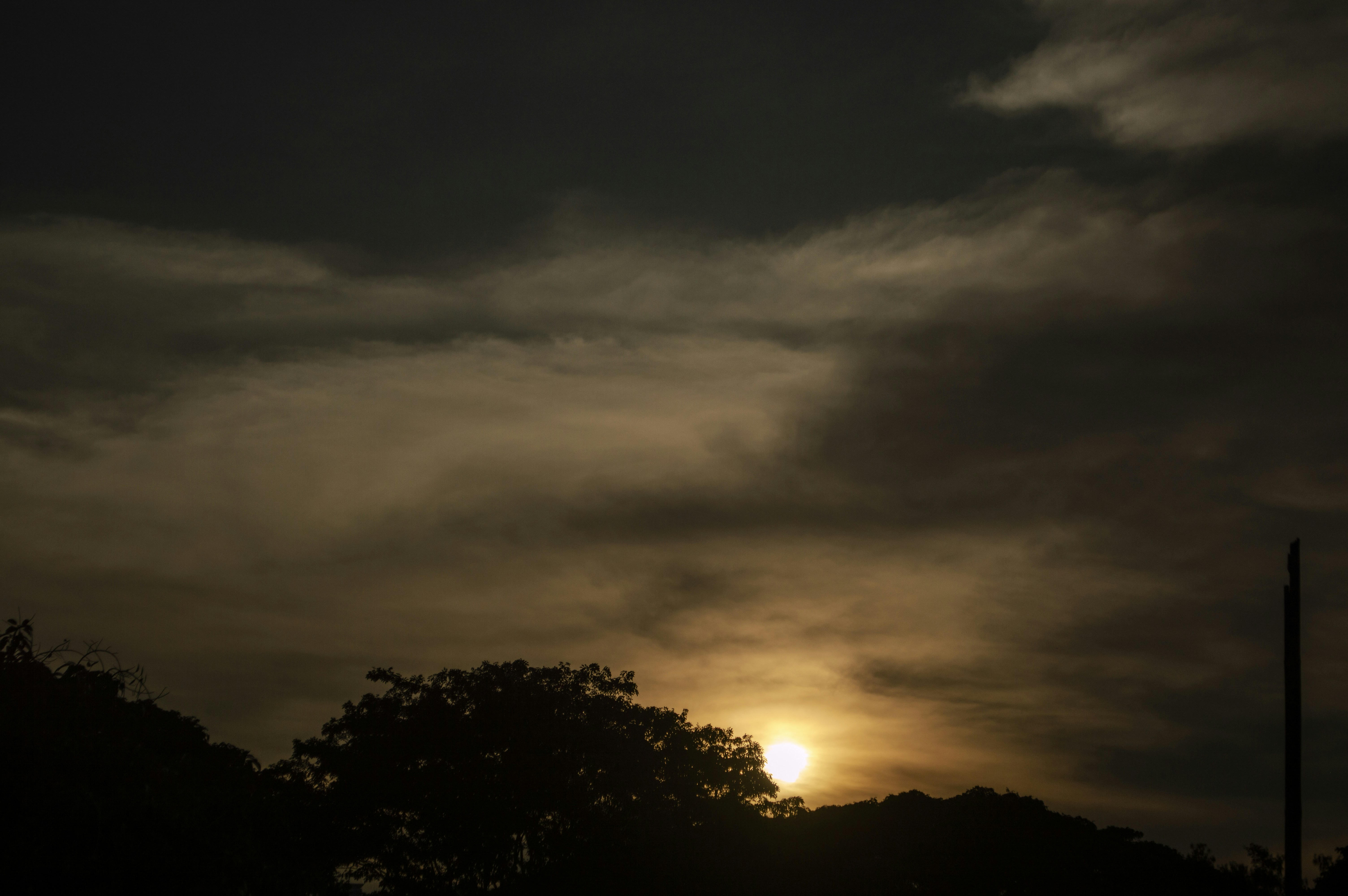 the sun is setting behind the clouds in the sky