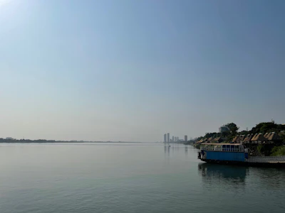 Wide open view of the Tonle Sap lake with a boat on the water (via Unsplash)