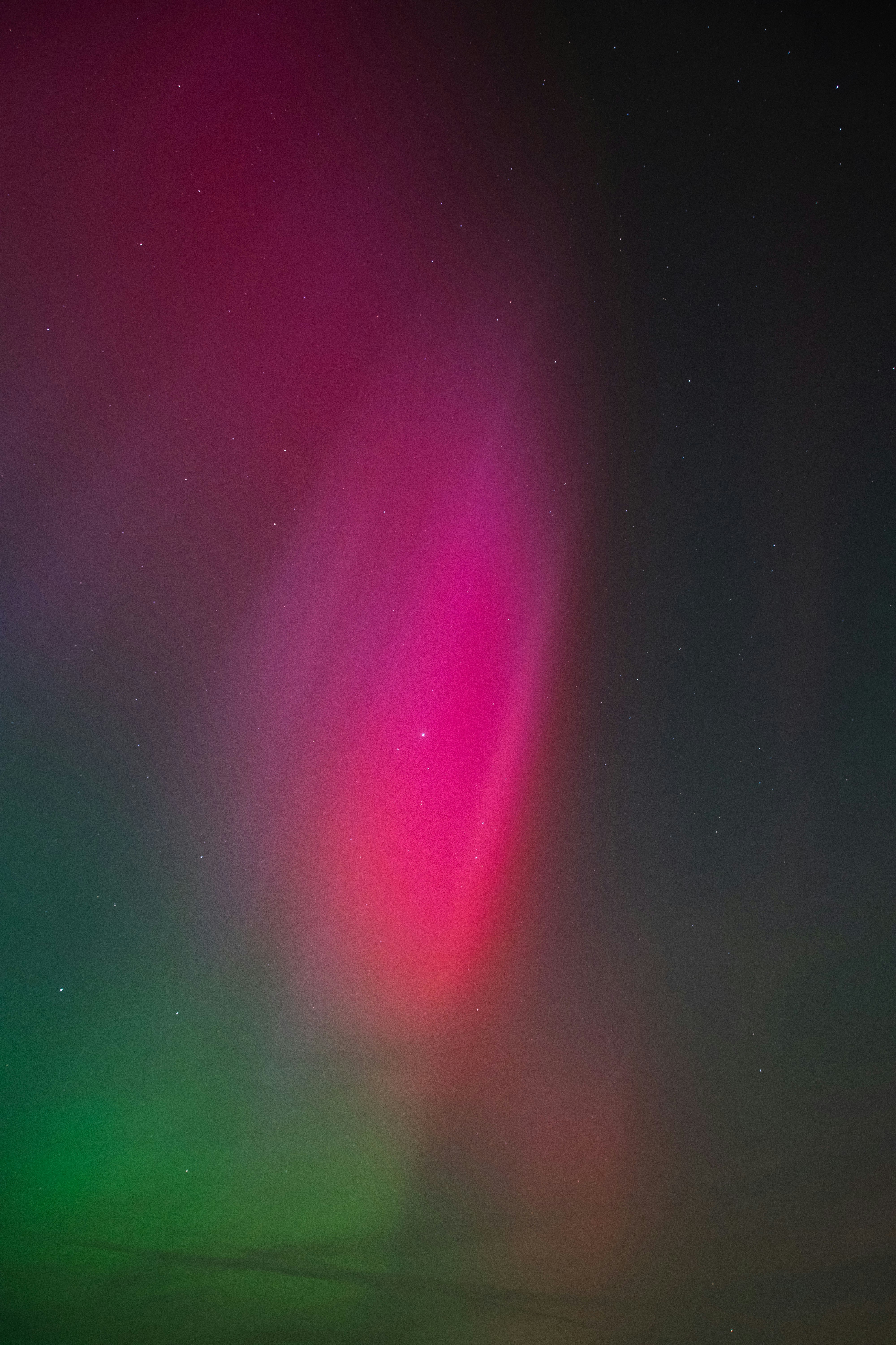 a bright pink and green aurora bore in the sky
