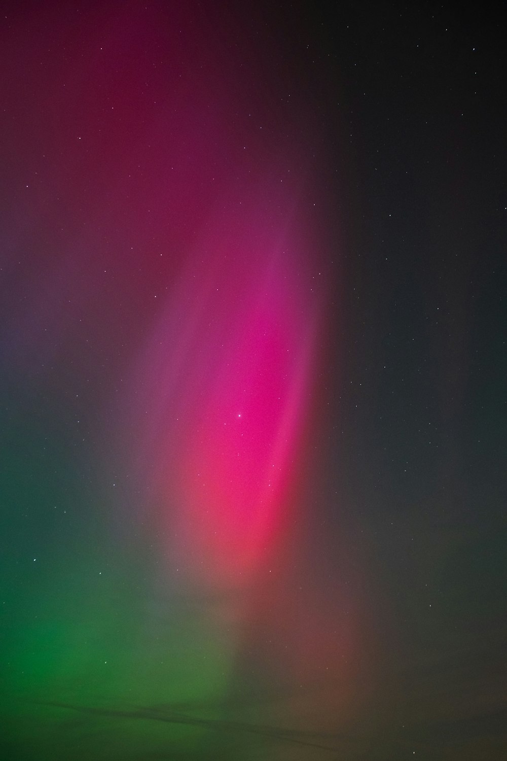 a bright pink and green aurora bore in the sky