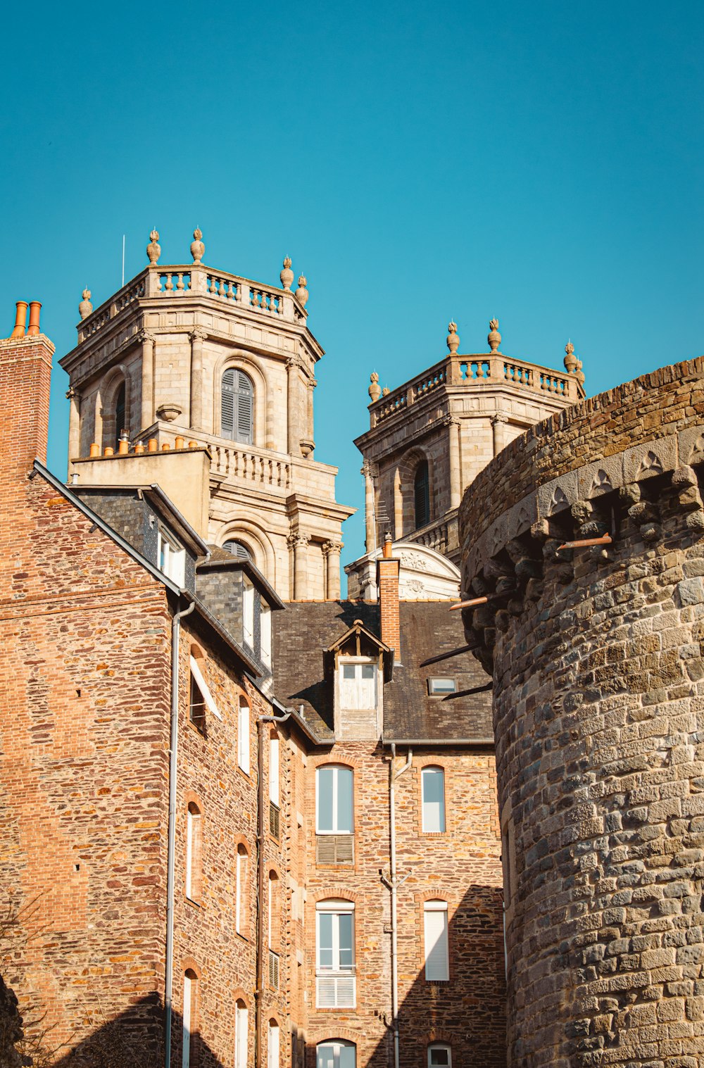 um edifício alto de tijolos com uma torre de relógio no topo dele