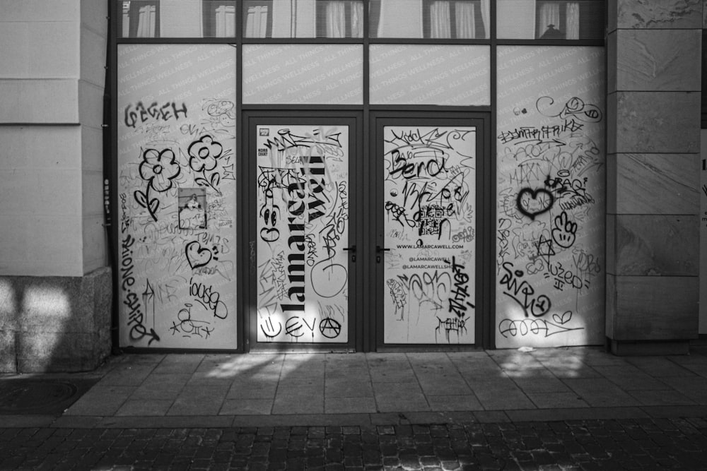 a black and white photo of a door covered in graffiti
