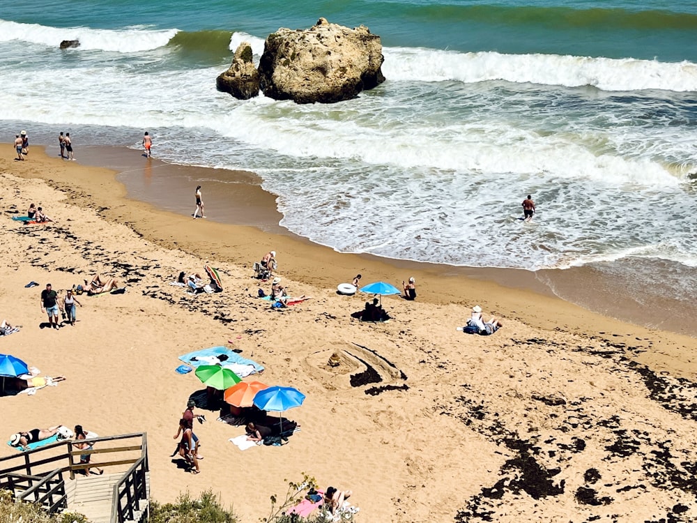 a beach filled with lots of people and umbrellas