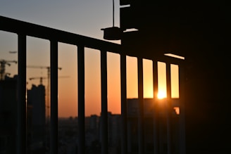 the sun is setting over a city with tall buildings