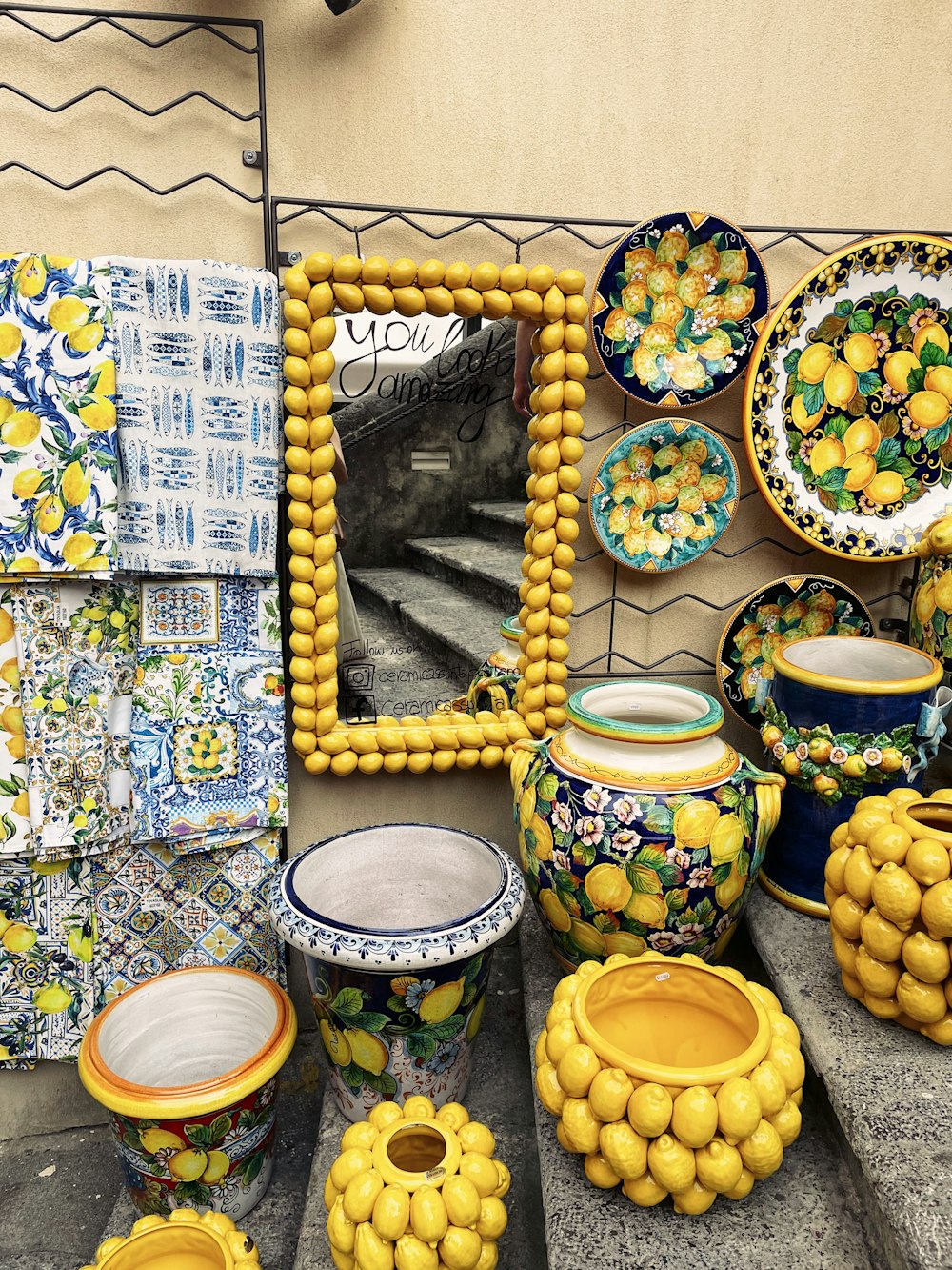 a group of yellow and blue vases sitting next to a mirror
