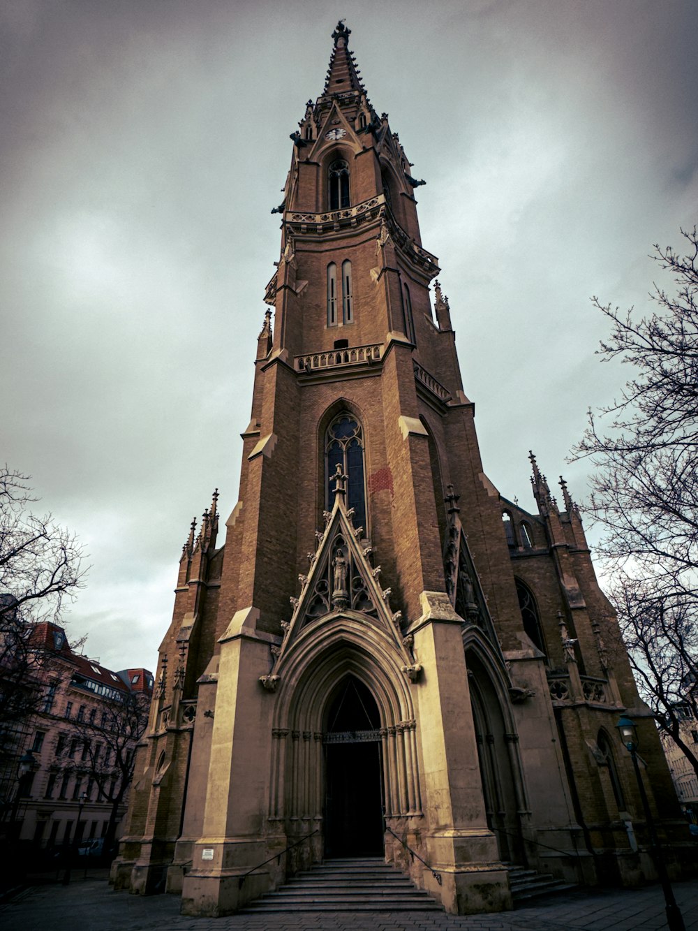 an old church with a steeple on a cloudy day