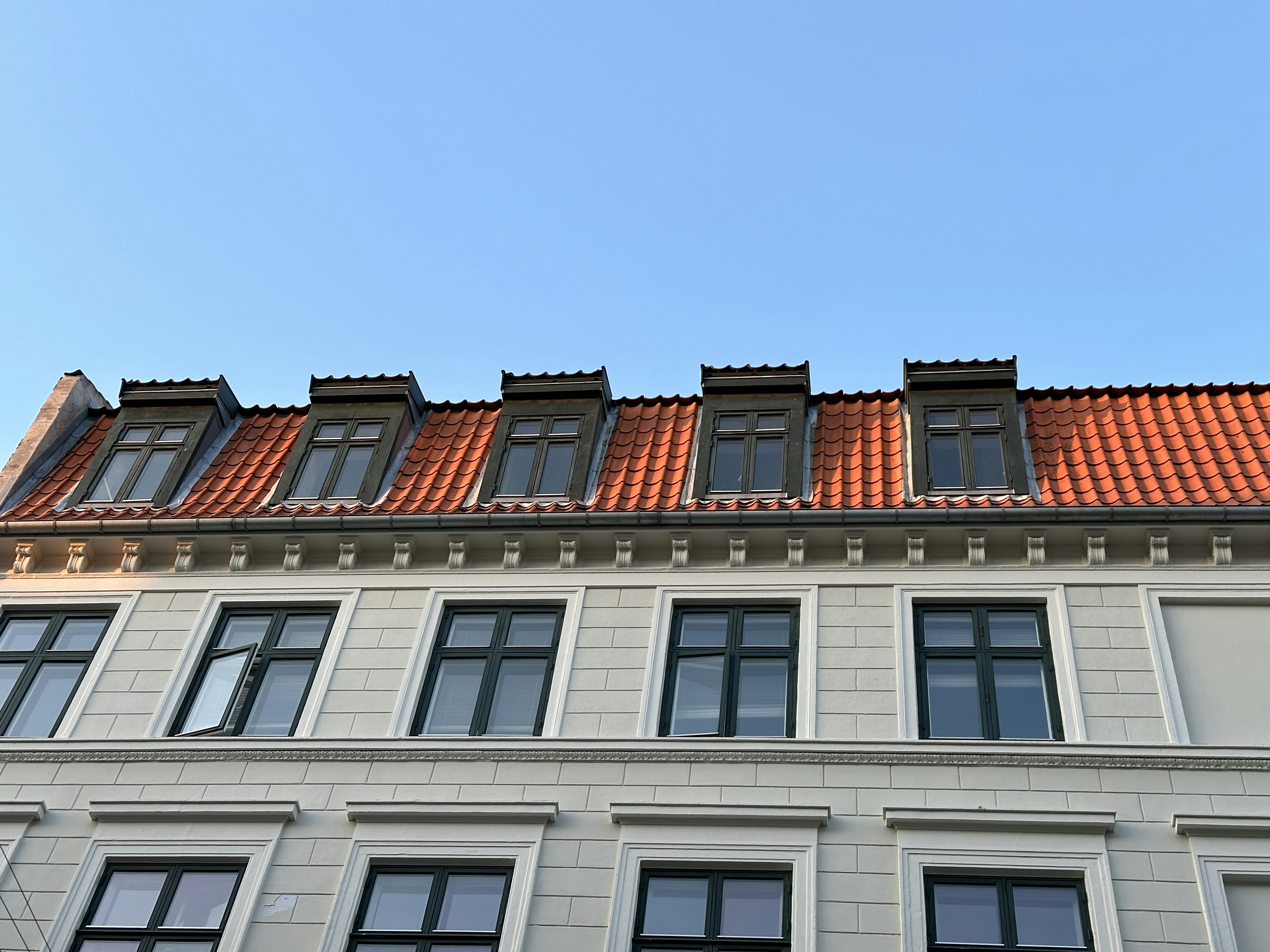 a building with a red tiled roof and windows