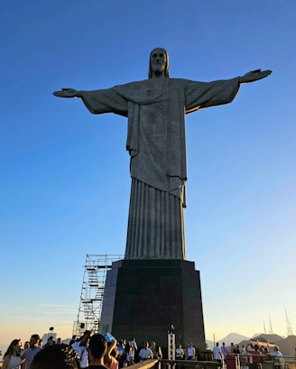 a crowd of people standing around a large statue the Christ The Redeemer, Rio de Janeiro, Brazil