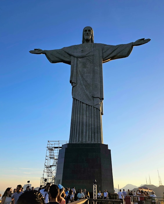 a crowd of people standing around a large statue the Christ The Redeemer, Rio de Janeiro, Brazil