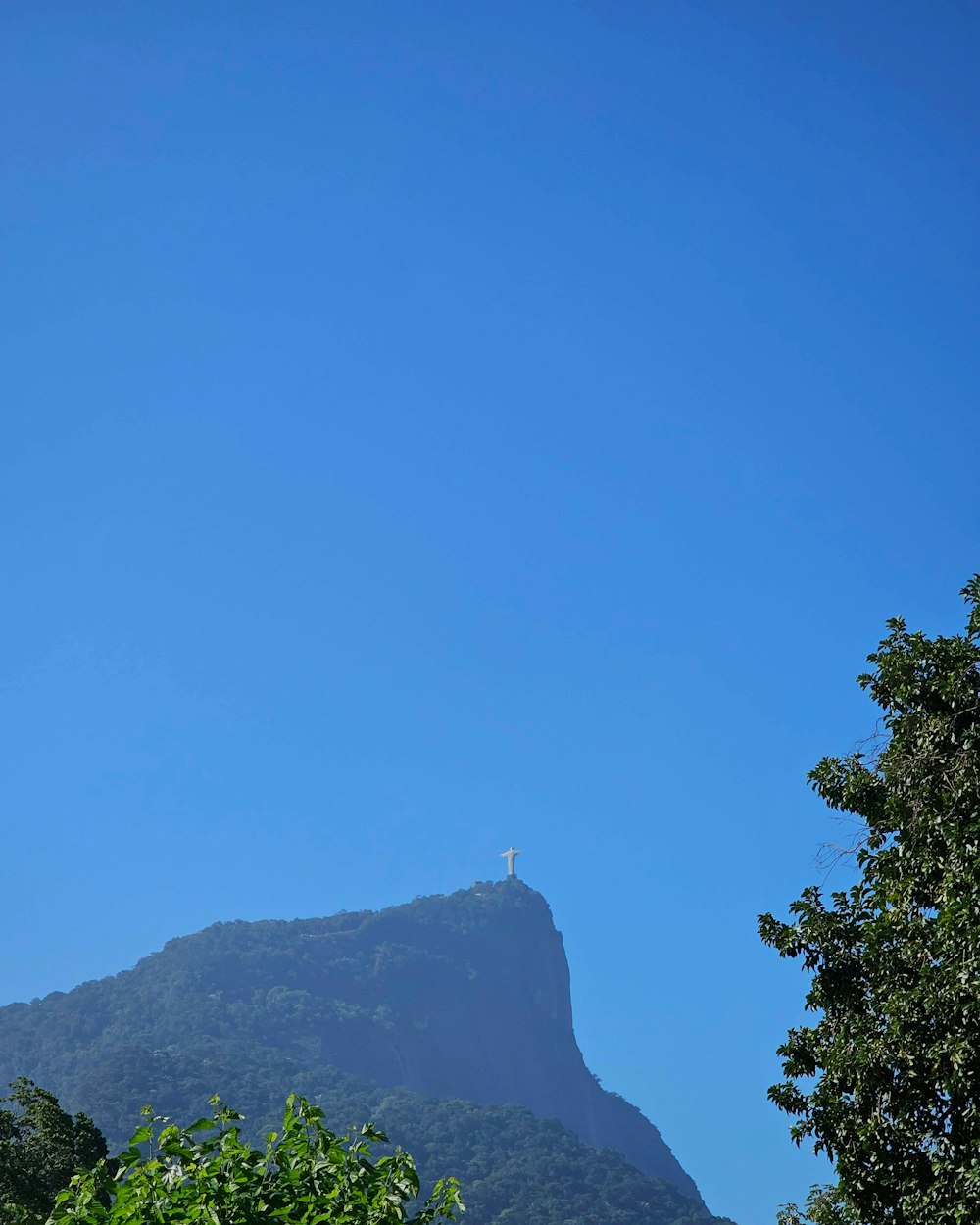 a tall mountain with a cross on top of it