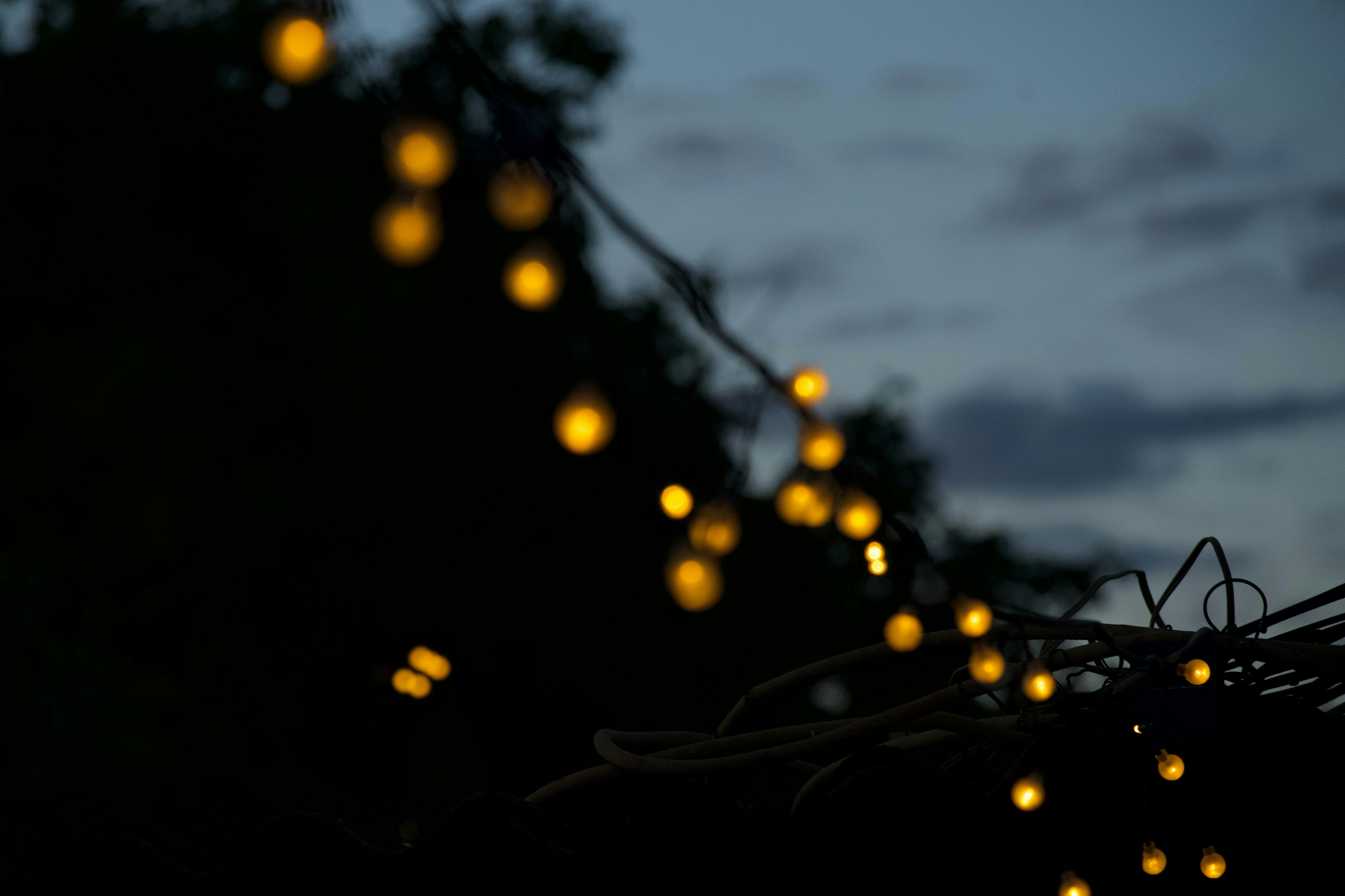 a string of yellow lights hanging from a wire