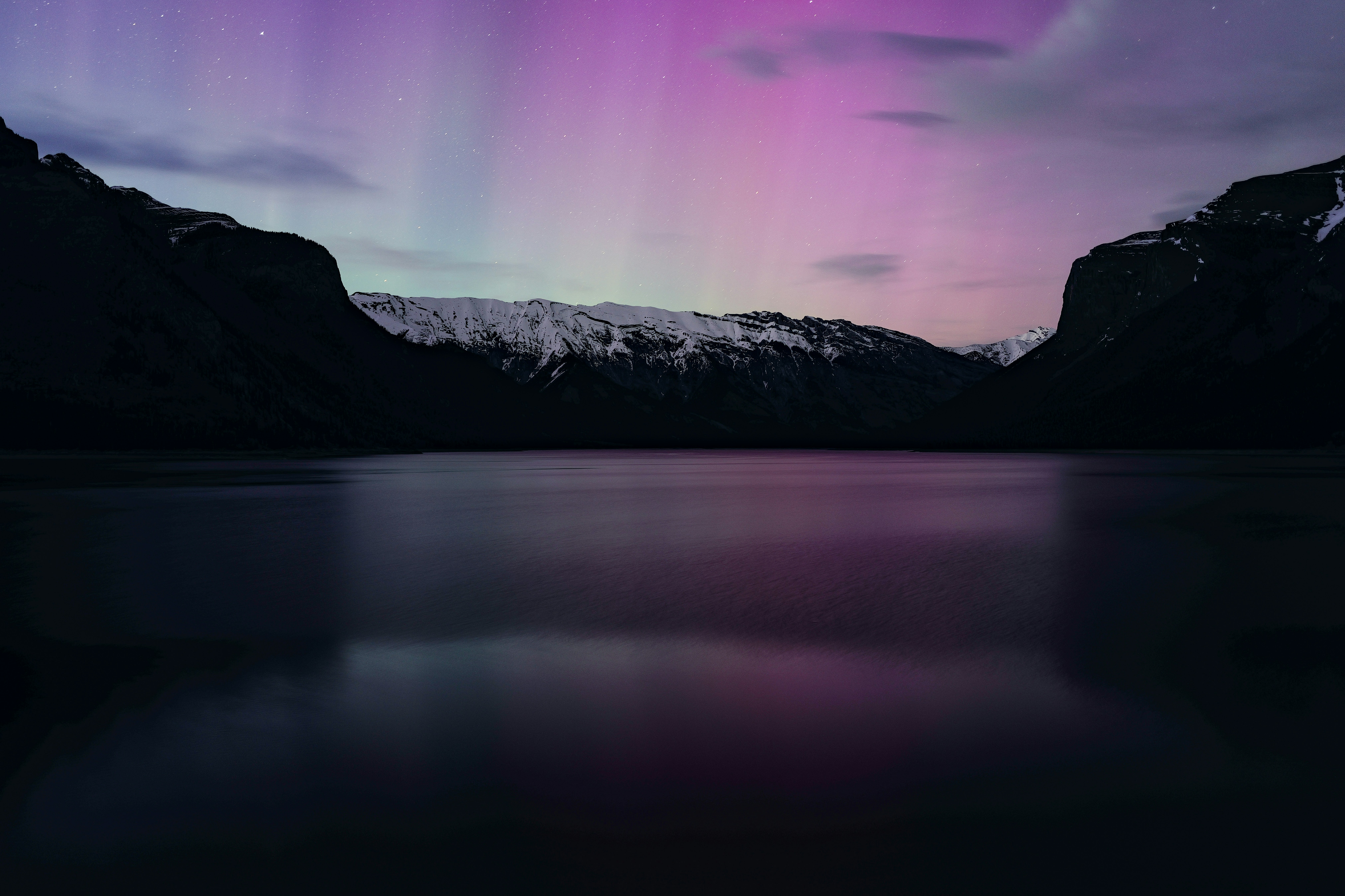 Northern lights over Lake Minnewanka in Alberta, Canada. I didn't bring a tripod, so pretty happy with how this turned out.