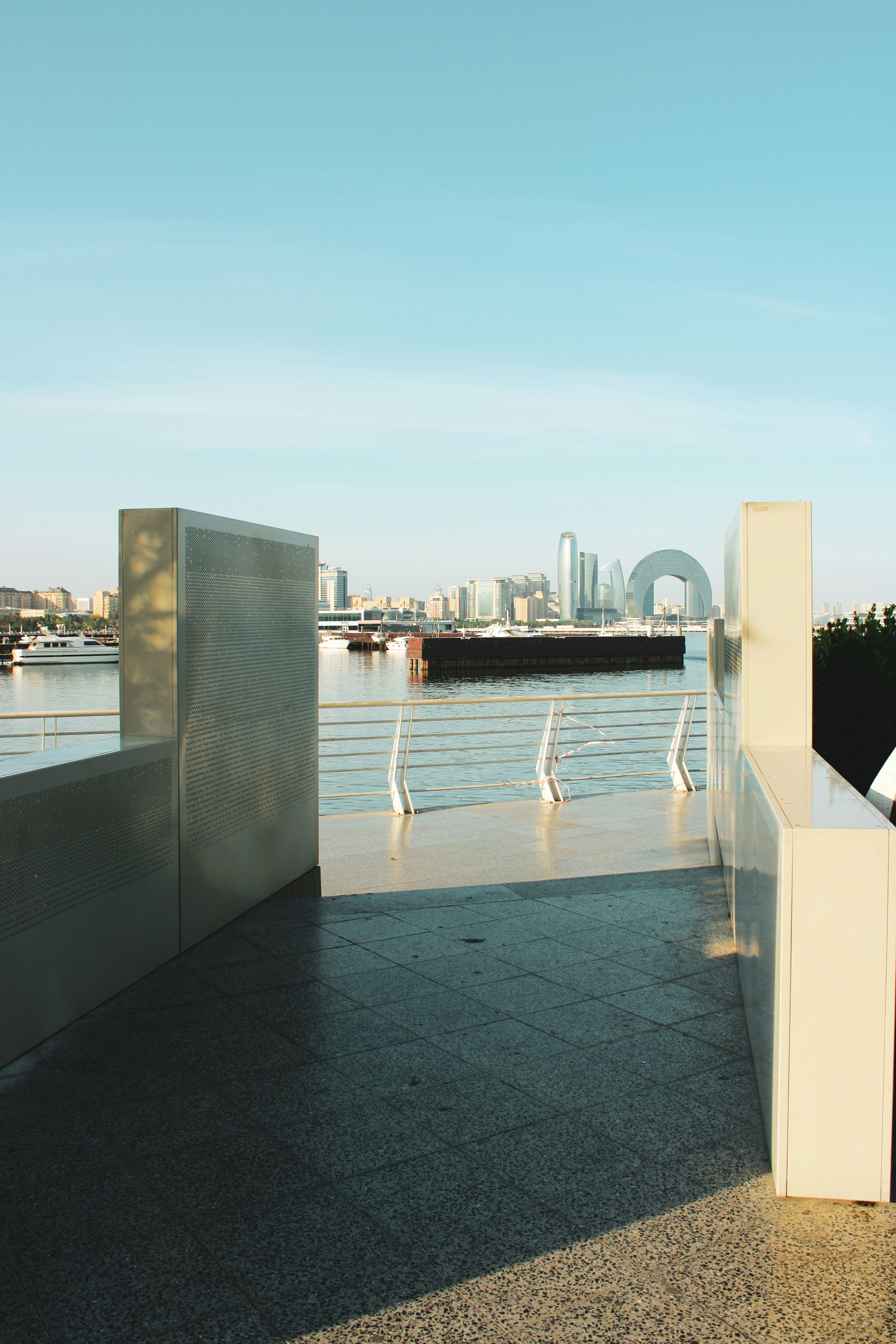 Un hombre parado en una acera junto a un cuerpo de agua