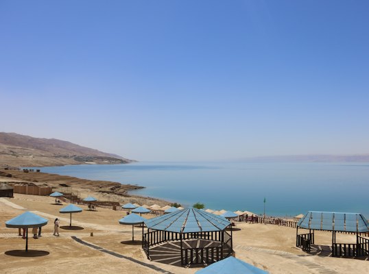 A group of umbrellas sitting on top of a sandy beach — Dead Sea, Jordan