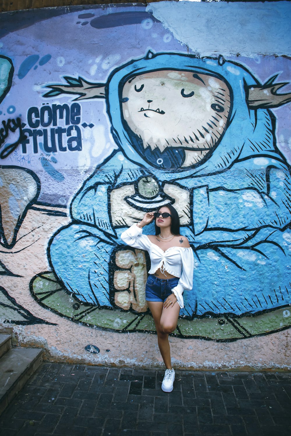 a woman standing in front of a graffiti wall