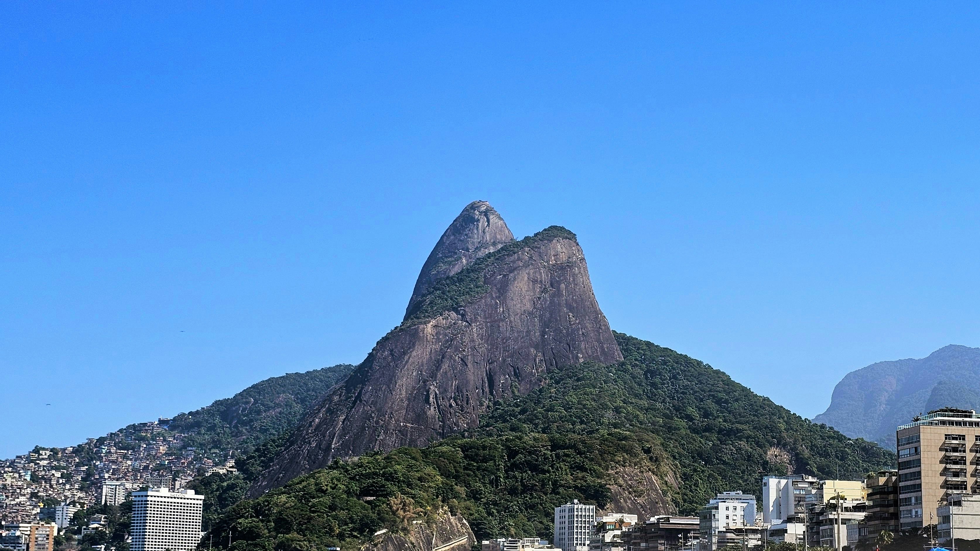a large mountain towering over a city with tall buildings