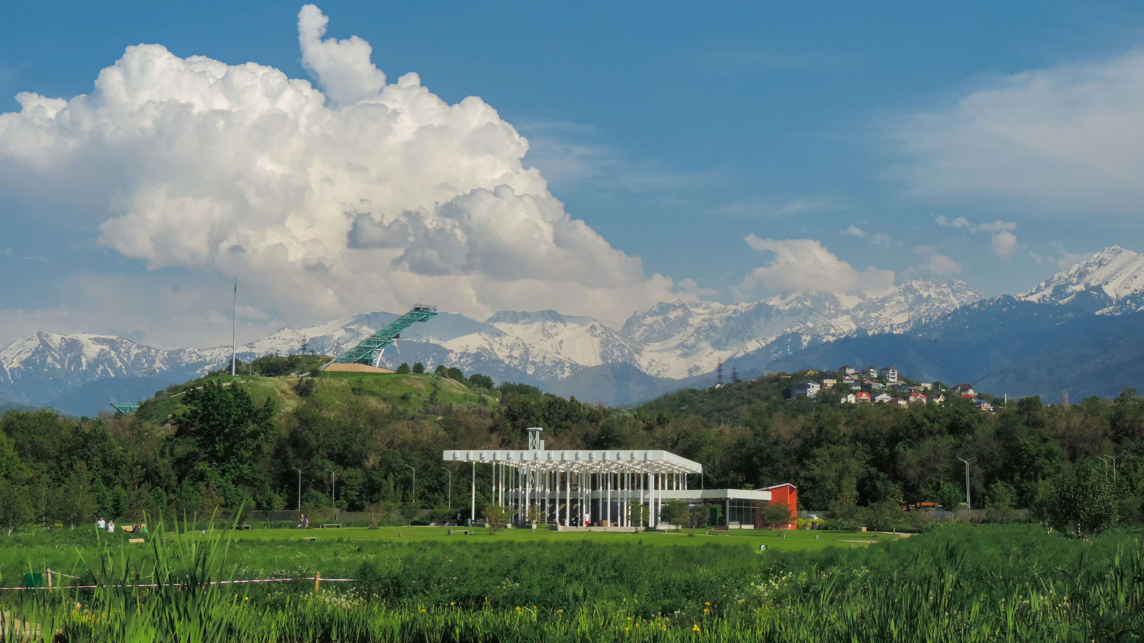 a building in a field with mountains in the background, 