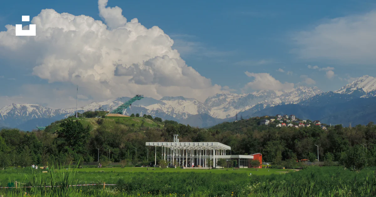 Building Ina Field A building in a field with mountains in the background photo – Free ...