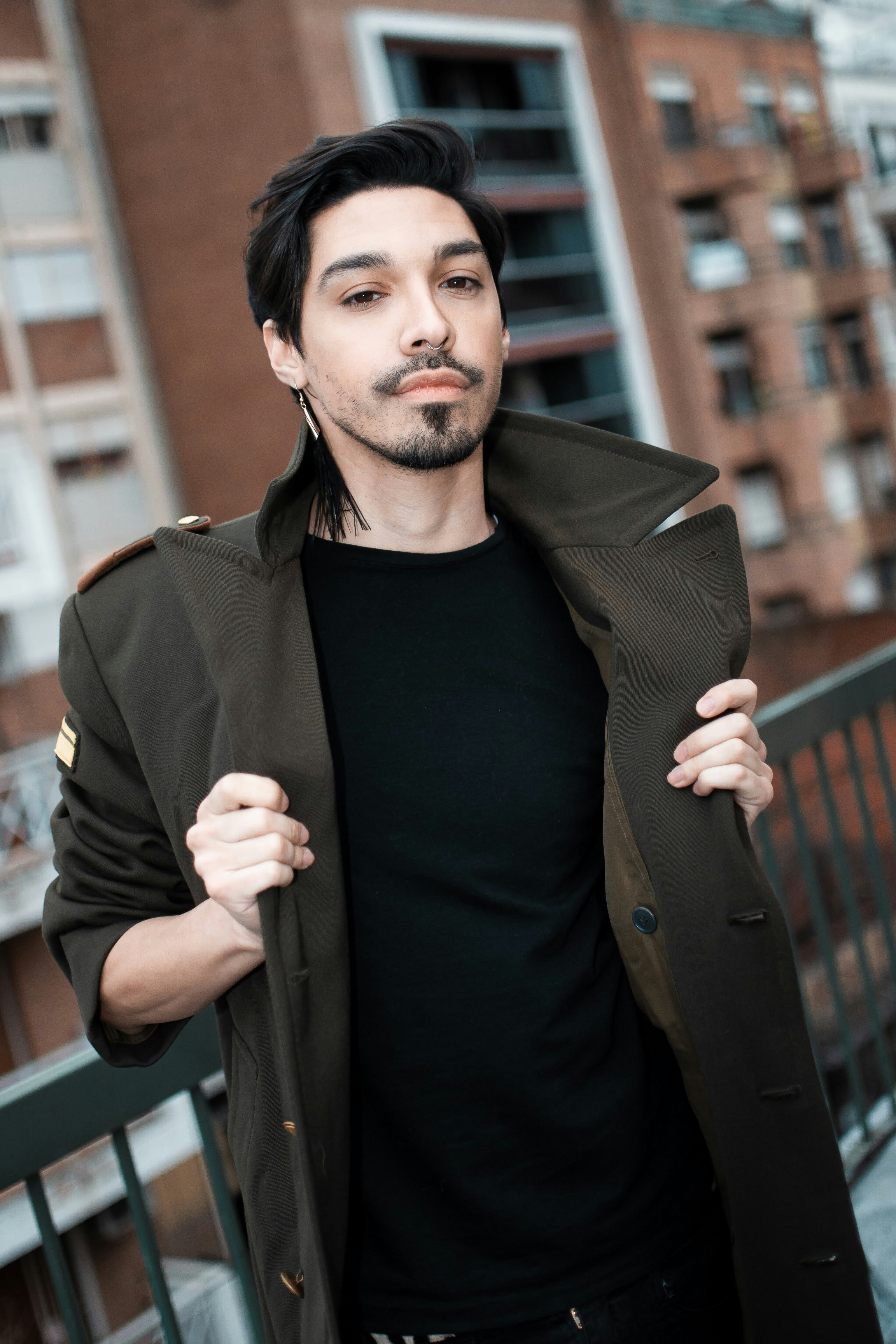a man in a black shirt and a coat