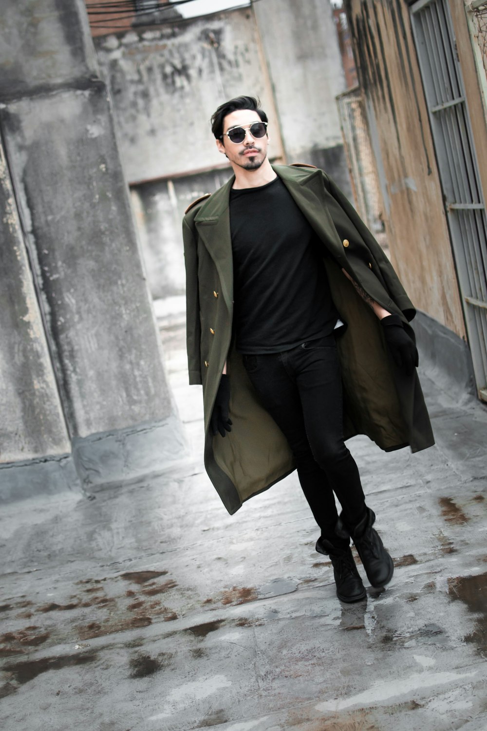 a man in a black shirt and green coat